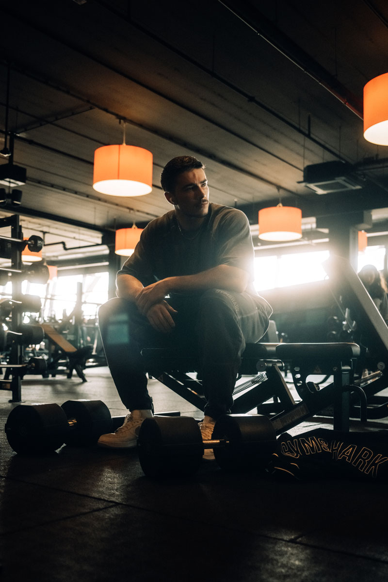 De coach zit in de gymzaal.